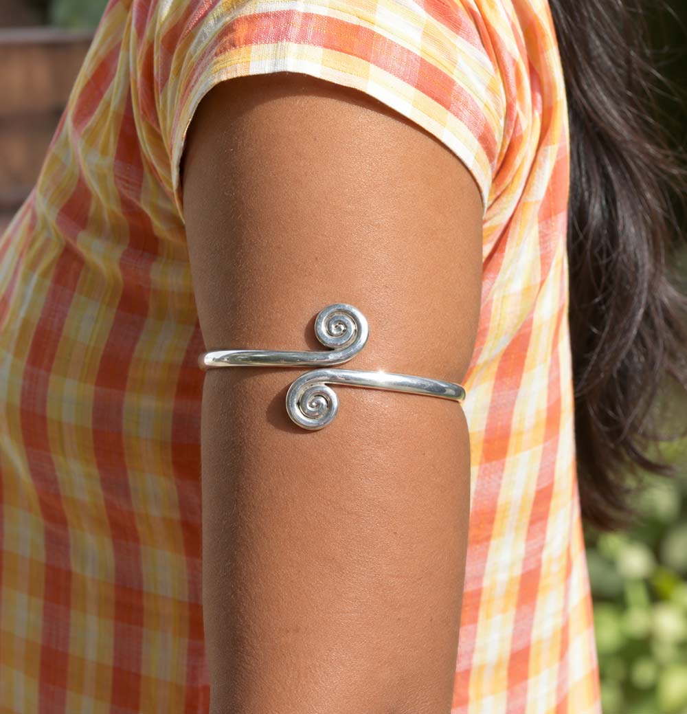Silver Twirl arm band worn on a woman's upper arm