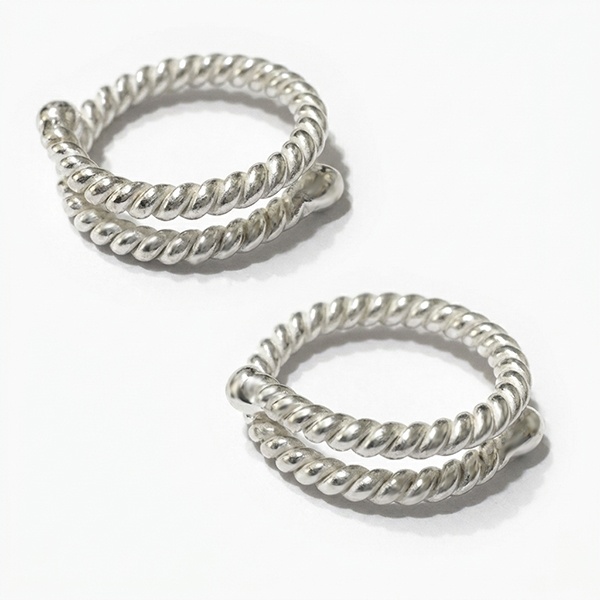Twisted non-piercing silver nipple ring worn on the breast