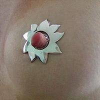 Large silver flower nipple shield worn on the breast